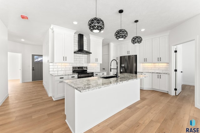 kitchen with white cabinets, wall chimney range hood, and stainless steel appliances