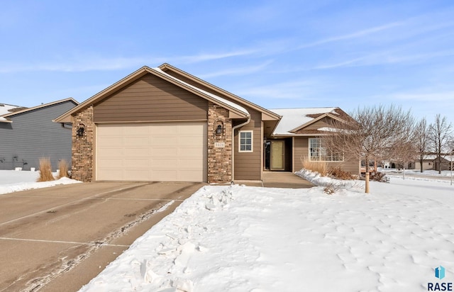 view of front of house featuring a garage, driveway, and brick siding