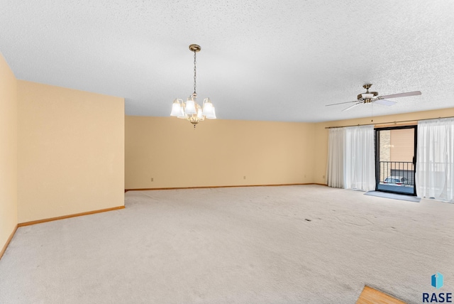 carpeted spare room featuring a textured ceiling, ceiling fan with notable chandelier, and baseboards