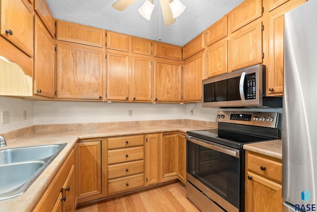 kitchen with light countertops, appliances with stainless steel finishes, and a sink