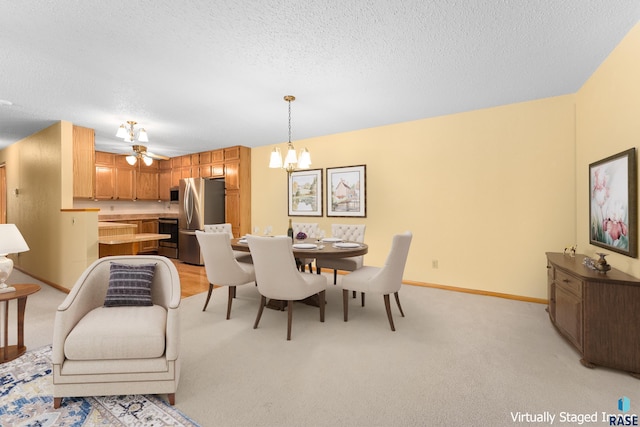 dining space featuring a textured ceiling, ceiling fan with notable chandelier, light colored carpet, and baseboards