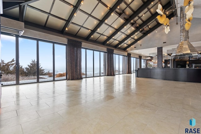 interior space featuring light tile patterned floors, high vaulted ceiling, beamed ceiling, and a water view