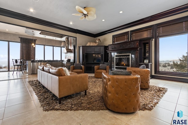 living room featuring crown molding, light tile patterned floors, recessed lighting, a premium fireplace, and a ceiling fan