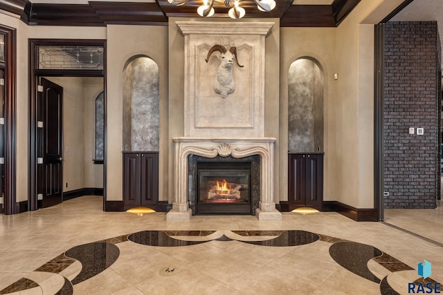 sitting room with a towering ceiling, baseboards, ornamental molding, and a high end fireplace