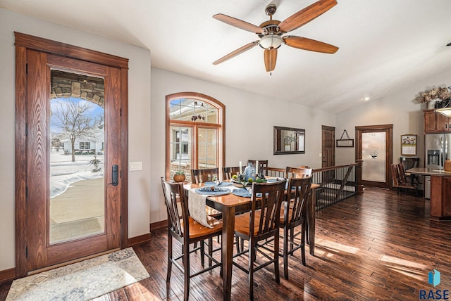 dining space with lofted ceiling, dark wood-type flooring, a ceiling fan, and baseboards