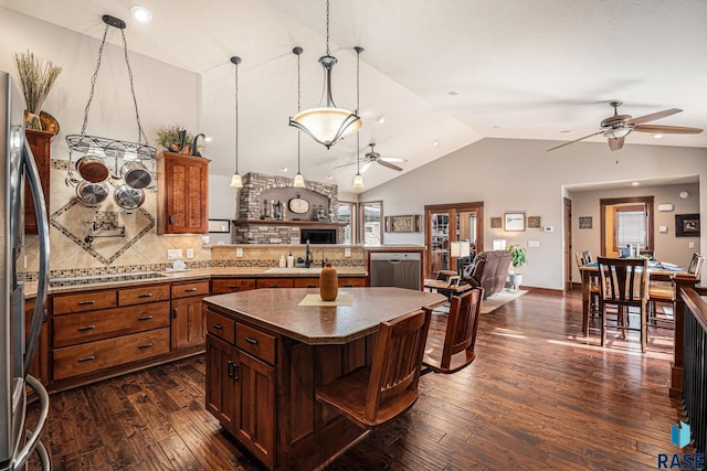 kitchen with stainless steel appliances, dark wood-style flooring, open floor plan, a center island, and pendant lighting