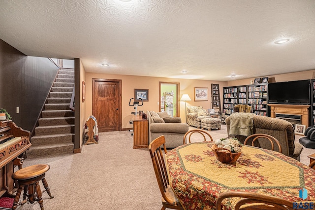 dining area featuring light colored carpet, a textured ceiling, baseboards, and stairs