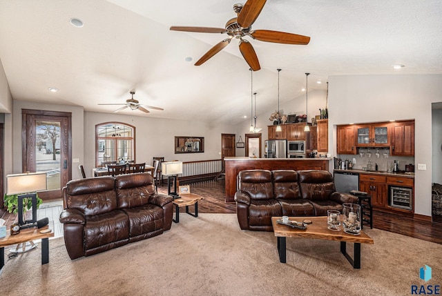 living room featuring beverage cooler, indoor bar, light colored carpet, ceiling fan, and high vaulted ceiling