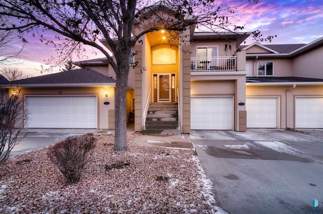 view of front of home with concrete driveway, a balcony, and stucco siding