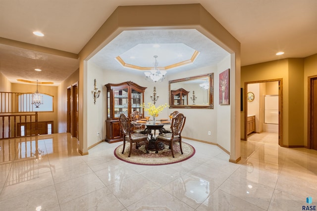 dining space with recessed lighting, a raised ceiling, baseboards, and an inviting chandelier