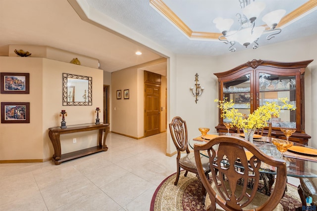 dining room with light tile patterned floors, baseboards, ornamental molding, a raised ceiling, and an inviting chandelier