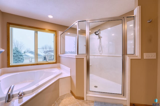 bathroom with a shower stall, a bath, and tile patterned floors