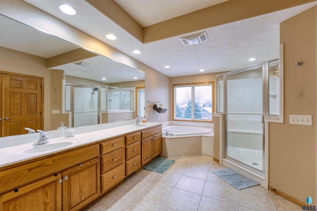 full bathroom featuring double vanity, visible vents, tile patterned floors, a shower stall, and a sink