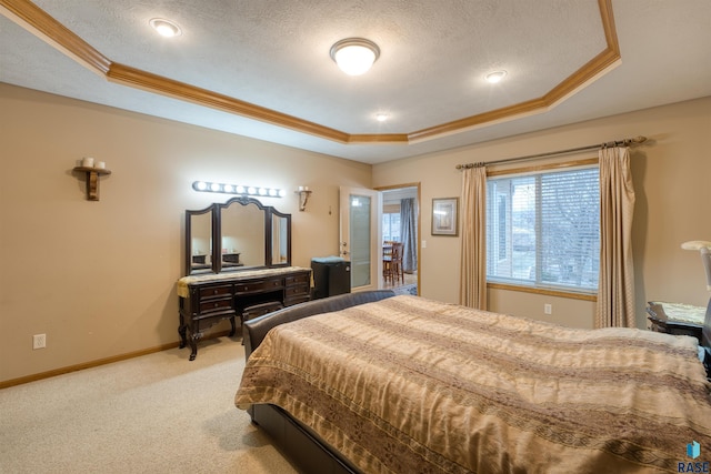 carpeted bedroom with a textured ceiling, a tray ceiling, and crown molding