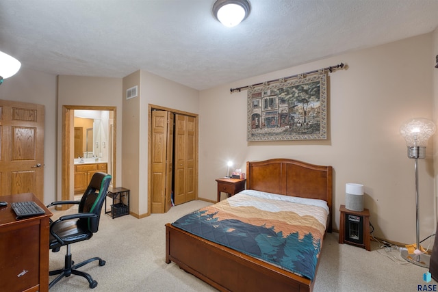 bedroom with a textured ceiling, light colored carpet, visible vents, baseboards, and a closet