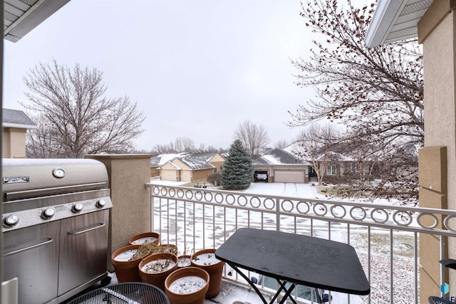 snow covered back of property with area for grilling