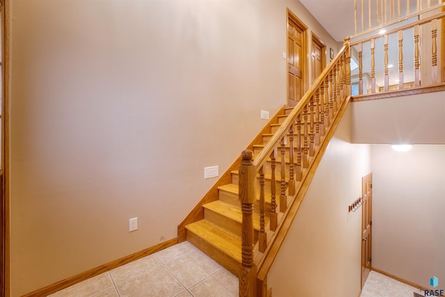 stairway featuring visible vents, baseboards, and tile patterned floors