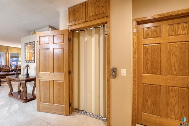 corridor featuring light tile patterned floors and elevator