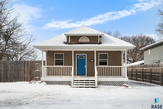 bungalow-style home featuring a porch and fence