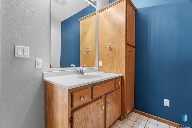 bathroom featuring vanity, baseboards, and tile patterned floors