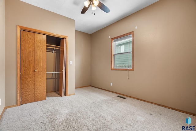 unfurnished bedroom featuring a ceiling fan, visible vents, baseboards, a closet, and carpet