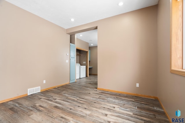 empty room with recessed lighting, visible vents, separate washer and dryer, wood finished floors, and baseboards