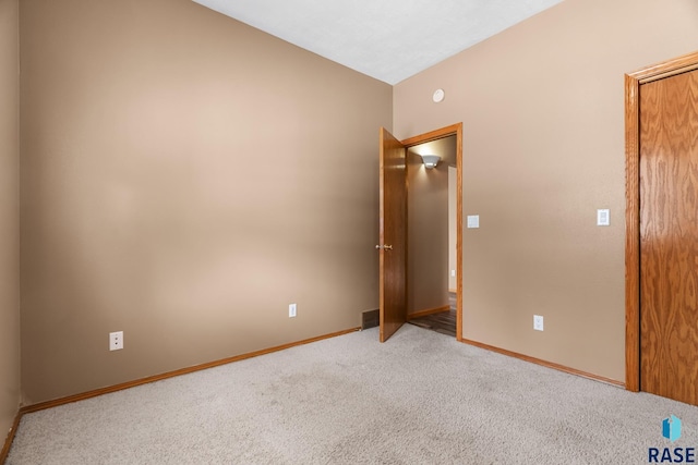 carpeted spare room featuring baseboards