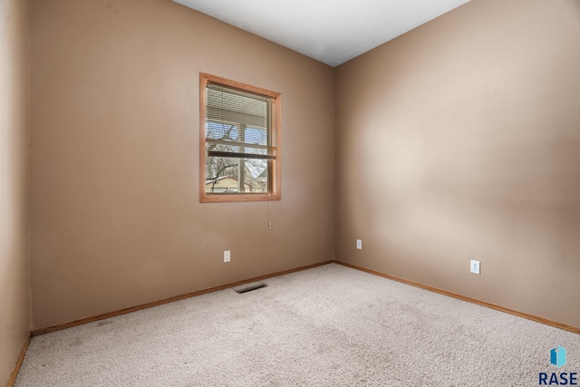 carpeted empty room featuring visible vents and baseboards