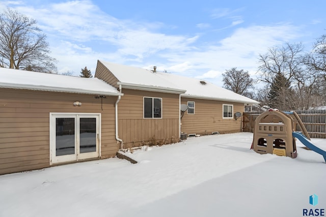 snow covered rear of property with fence