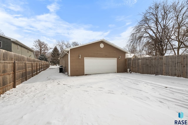 exterior space featuring a detached garage, fence, and an outdoor structure