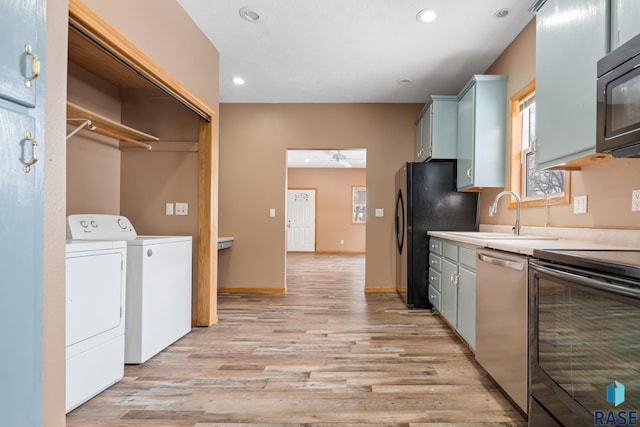 kitchen featuring washer and dryer, electric stove, stainless steel dishwasher, light countertops, and freestanding refrigerator