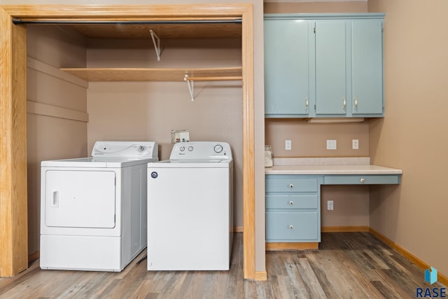 laundry room with cabinet space, baseboards, wood finished floors, and independent washer and dryer