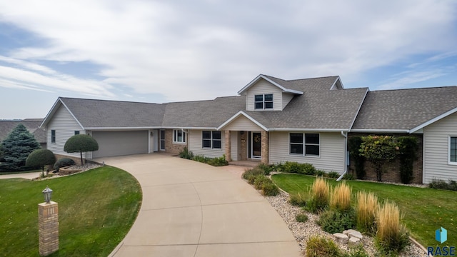 view of front facade featuring an attached garage, a shingled roof, a front lawn, and concrete driveway