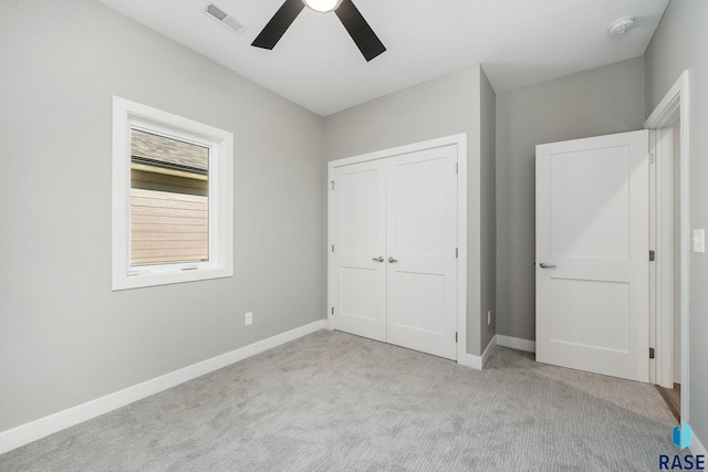 unfurnished bedroom with ceiling fan, light colored carpet, visible vents, baseboards, and a closet