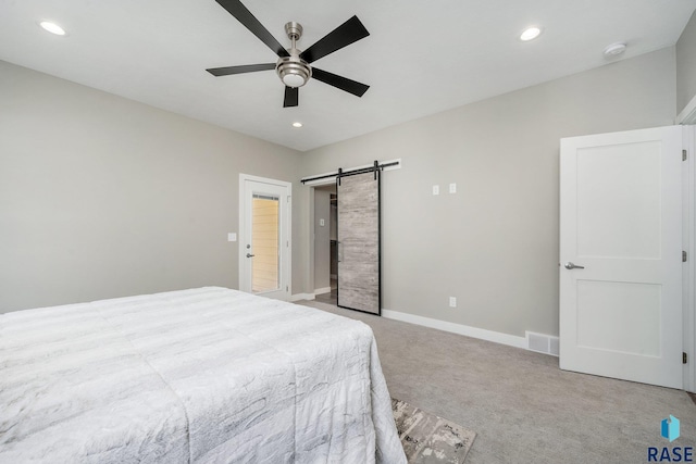 unfurnished bedroom featuring recessed lighting, a barn door, baseboards, and light colored carpet