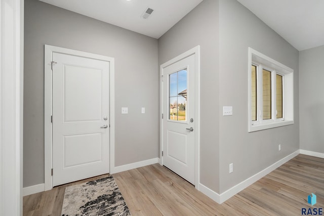 entrance foyer featuring light wood-style flooring, visible vents, and baseboards