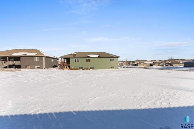 snow covered rear of property with a residential view