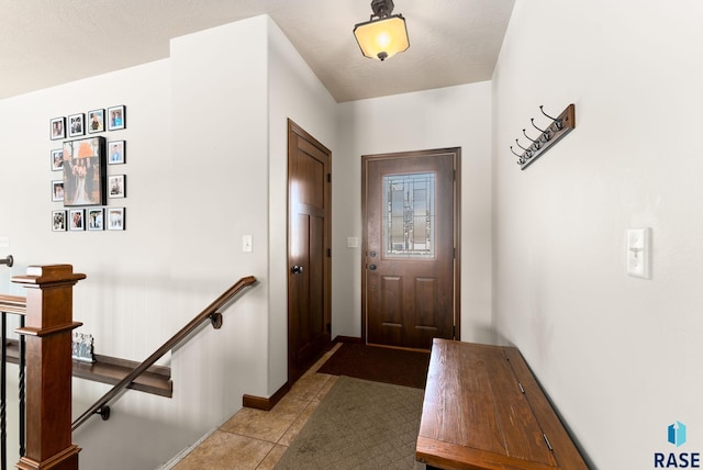 entryway with light tile patterned floors and baseboards