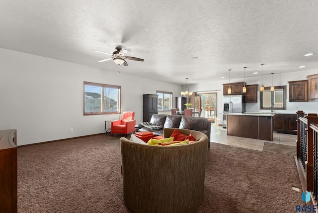 living area featuring ceiling fan with notable chandelier, a textured ceiling, and light colored carpet