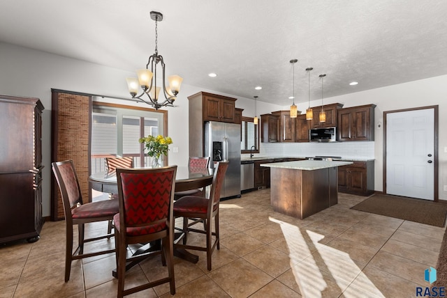 dining space with light tile patterned floors, a wealth of natural light, and a notable chandelier