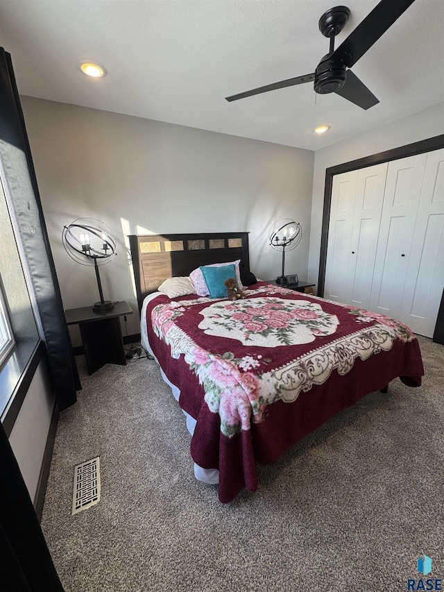 bedroom featuring dark colored carpet, a closet, visible vents, and a ceiling fan