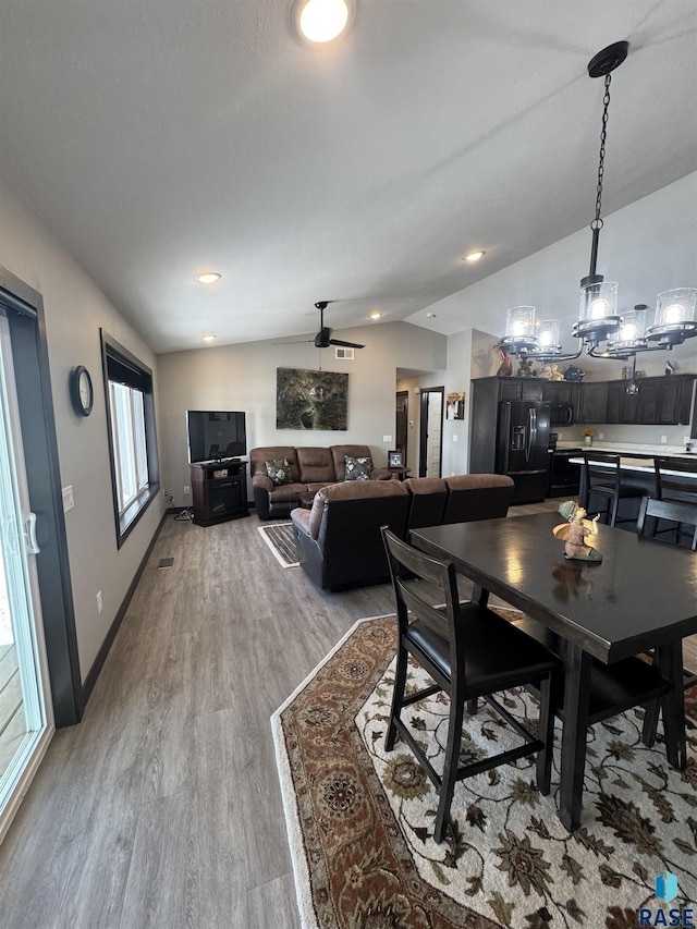 dining area with lofted ceiling, light wood-style flooring, and baseboards