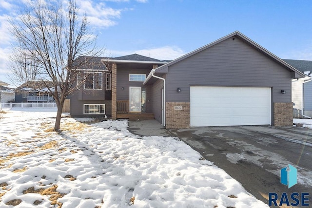 view of front of property featuring a garage, driveway, and brick siding