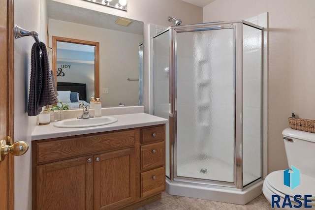 ensuite bathroom featuring tile patterned flooring, toilet, vanity, a stall shower, and ensuite bath