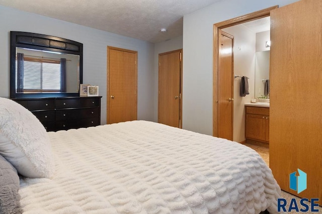 bedroom featuring a textured ceiling and ensuite bathroom