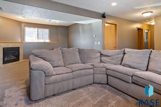 living area featuring carpet floors, recessed lighting, visible vents, and a fireplace