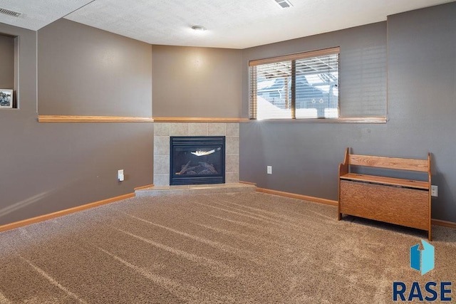 unfurnished living room with carpet floors, visible vents, and baseboards