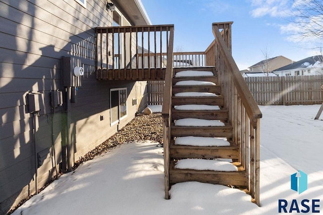 snow covered deck with stairs and fence