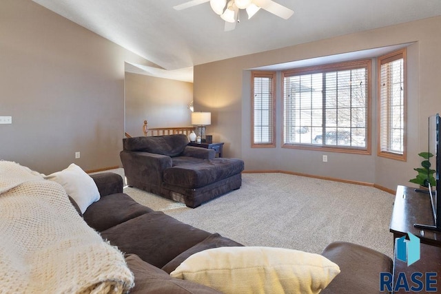 living room featuring ceiling fan, baseboards, vaulted ceiling, and light colored carpet