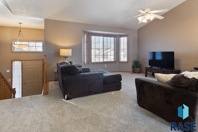 carpeted living area with ceiling fan, high vaulted ceiling, and baseboards